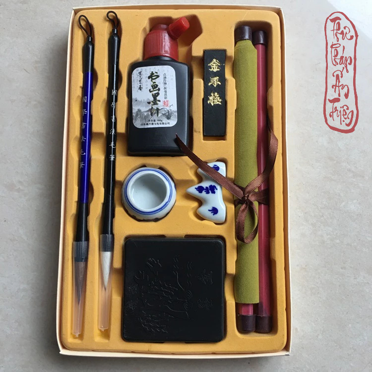 Bộ dụng cụ thư pháp trong hộp gồm hai bút lông, mực, nghiên, gác bút và cuộn vải