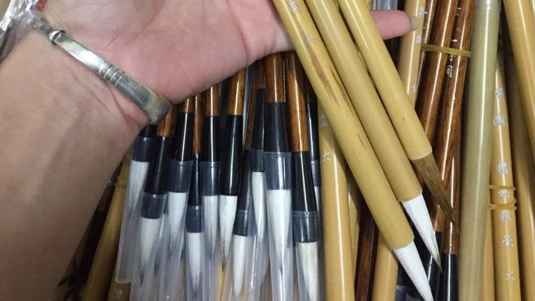 Bàn tay giữ nhiều cán bút lông thư pháp