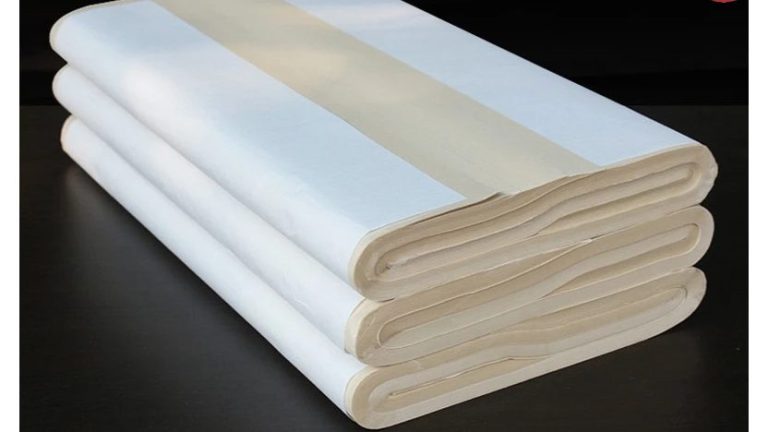 Các tờ giấy thư pháp trắng và ngả vàng được gấp, xếp thành chồng